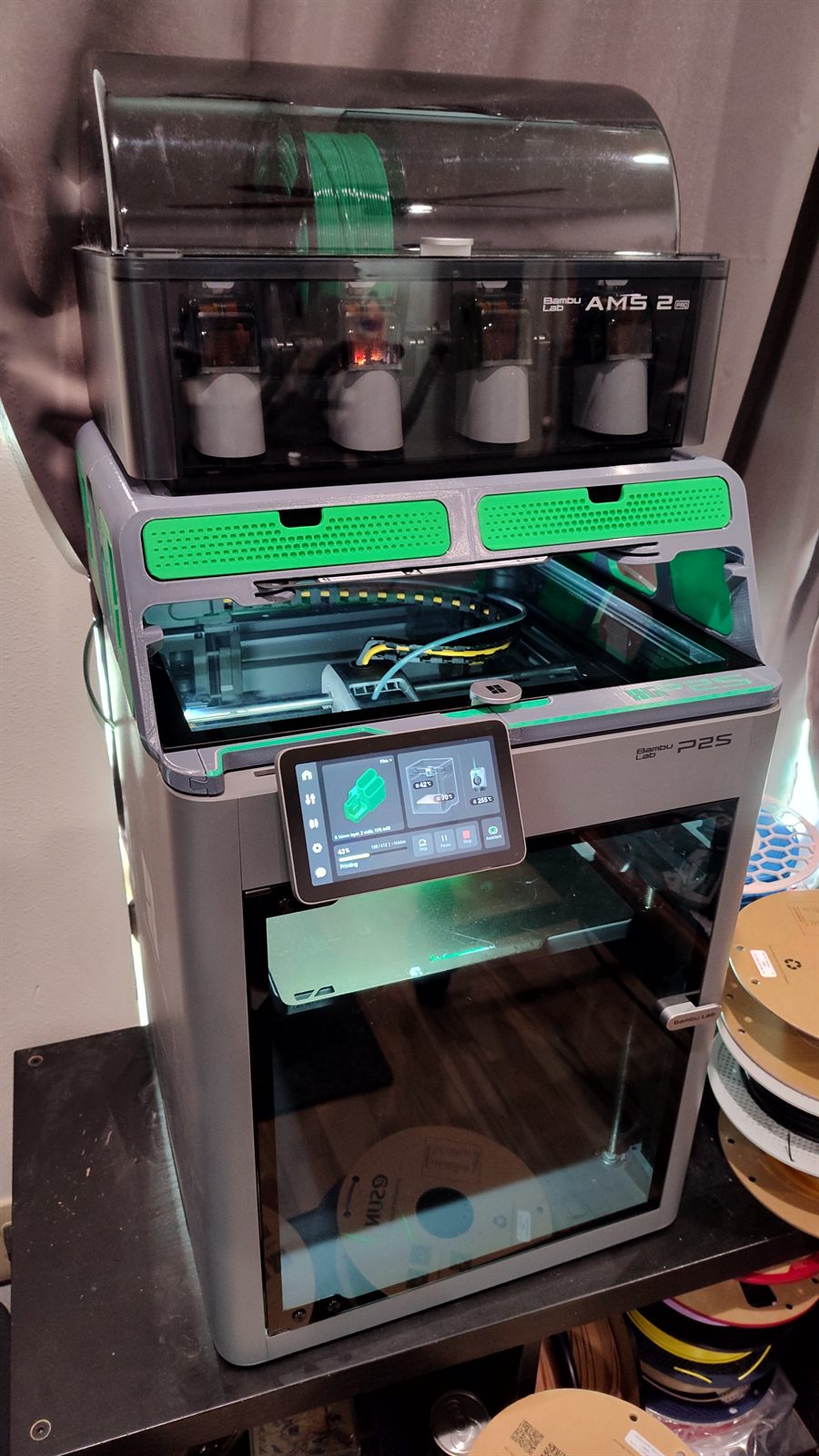 Bambu Lab P2S printer with AMS 2 Pro multi-spool unit on top, filament shelving behind
