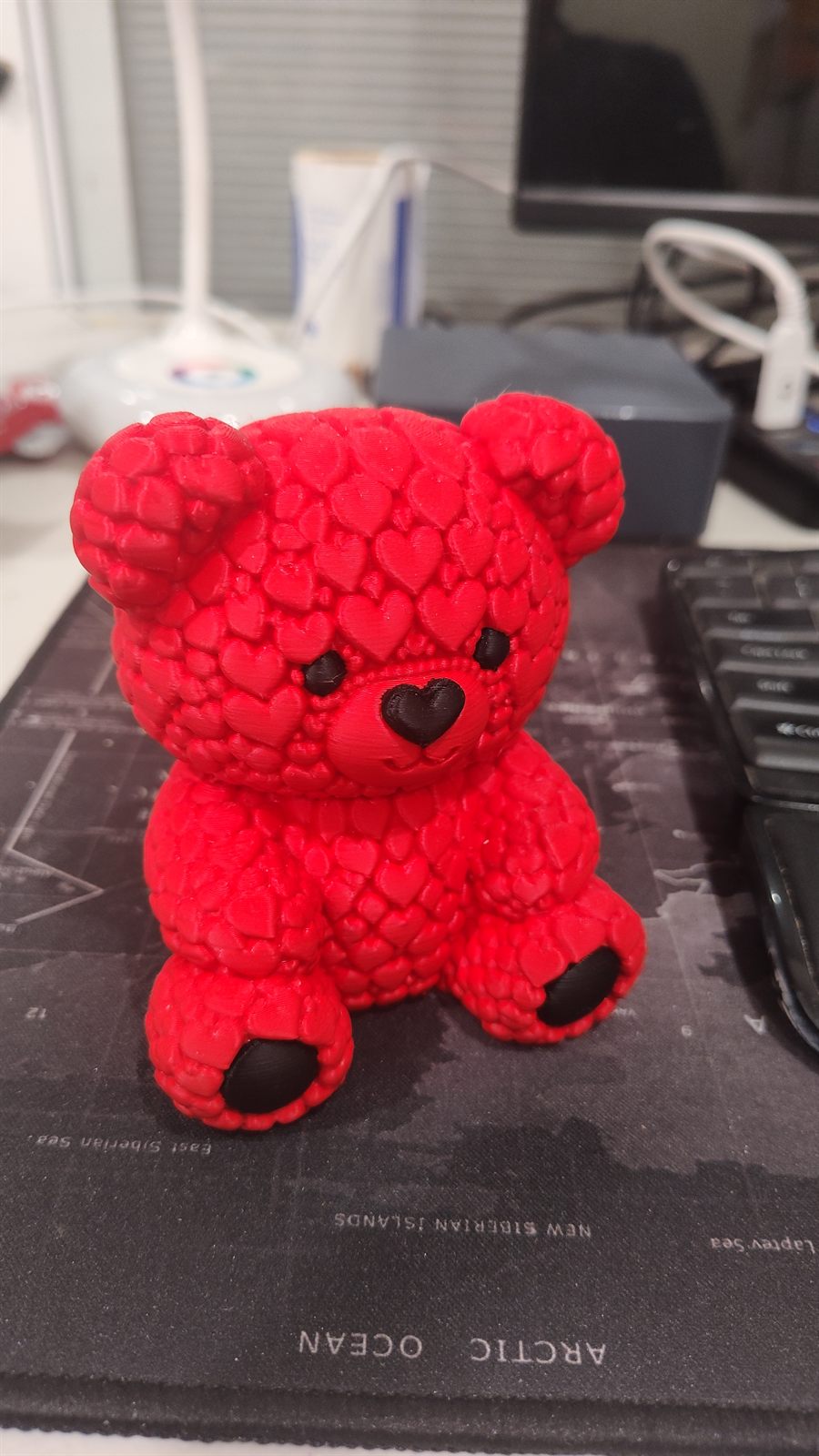 A red printed bear with heart-textured fur