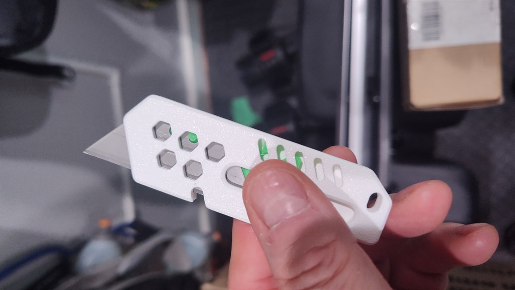 A white 3D-printed utility razor knife with a replaceable blade