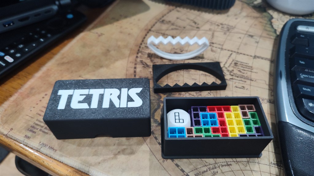 A printed Tetris balance game with colorful pieces and a storage box