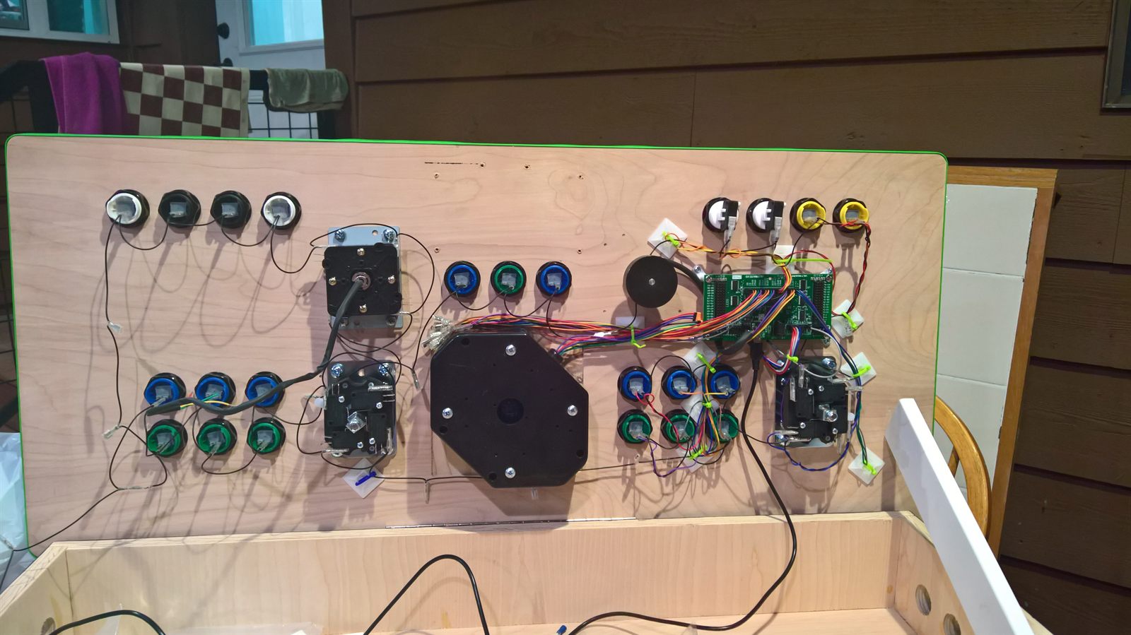 Wider view of the wired panel underside with joysticks, trackball, and spinner installed