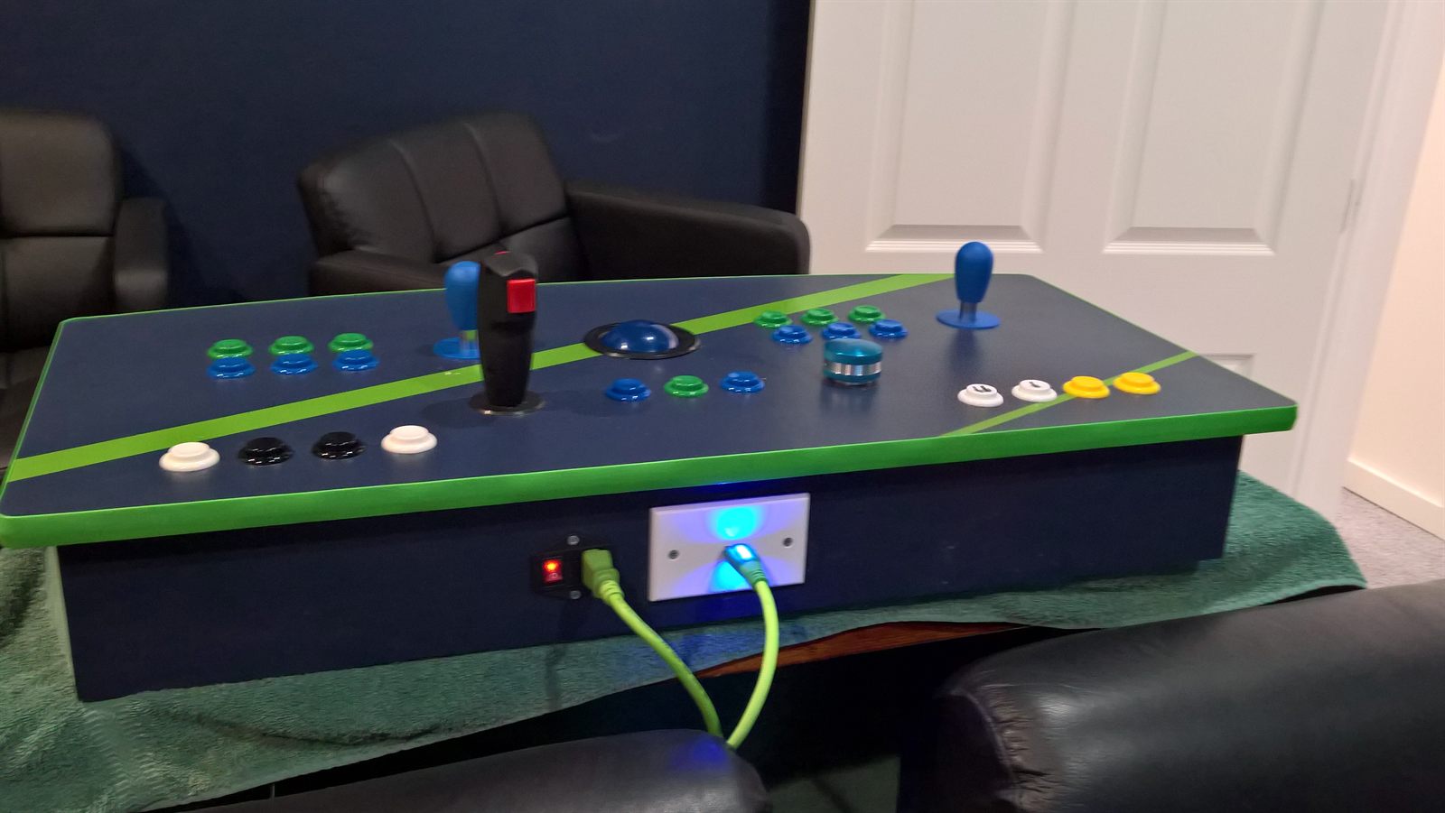 Finished two-player arcade control panel with joysticks, trackball, spinner, and lit power button