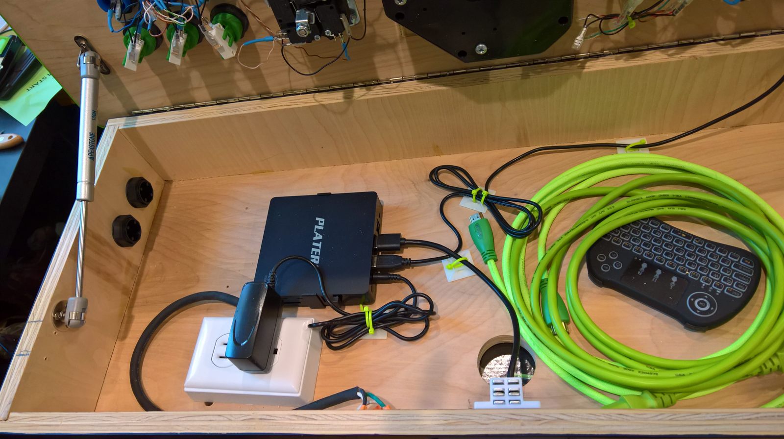 Inside the PC bay with mini PC, wireless keyboard, and coiled HDMI cable