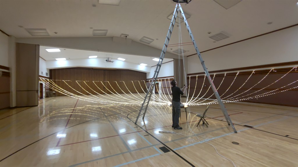 Fully assembled cultural hall lighting rig suspended during setup