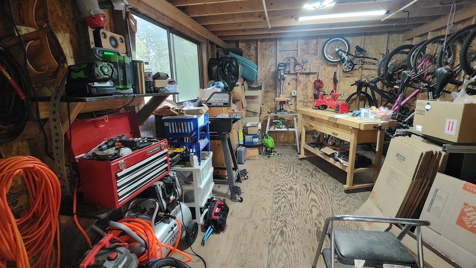 Wide view of the indoor turning shop with the workbench in the middle and tools on the walls