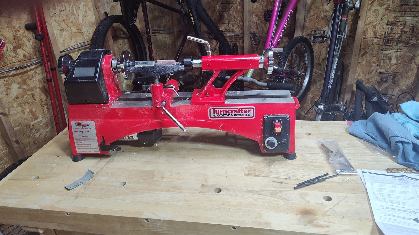 The red Penn State Turncrafter Commander 8-inch midi lathe sitting on the workbench top
